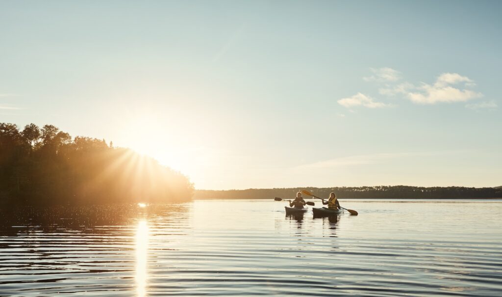 Couple kayaking on lake surrounded by trees at Farmington Lake in New Mexico.